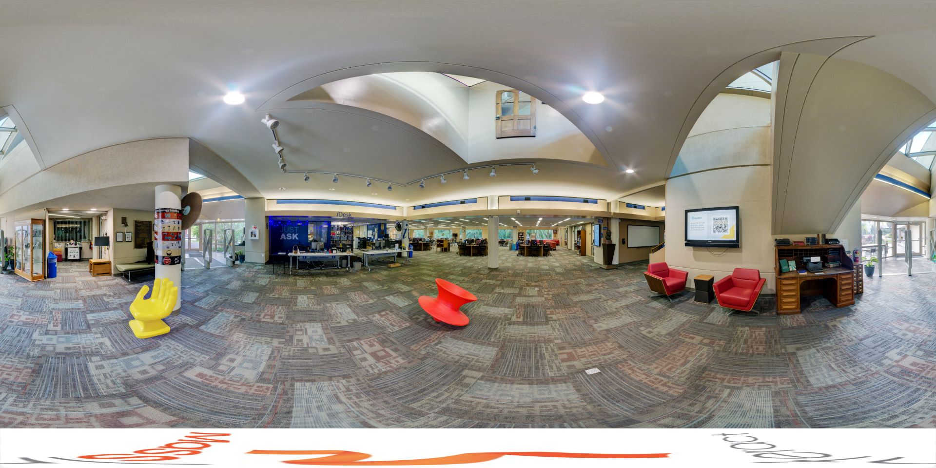 Interior panoramic view of the first floor of Evans Library, showcasing a spacious area with modern design elements and a central seating area.
